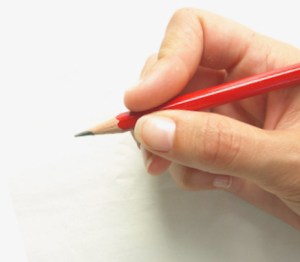 Hand holding a pencil and writing a novel